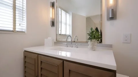 Well-lit bathroom with large rectangular mirror above sink vanity. Two modern Stock-Footage 262161465