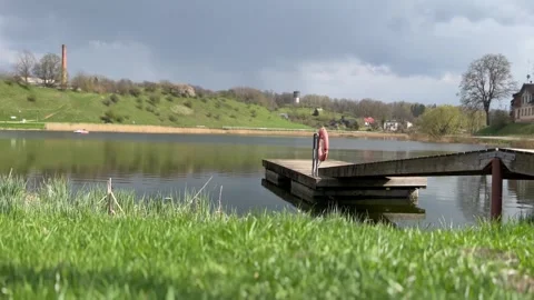Well-maintained wooden pier going into the lake with smooth water Stock Footage 240799737