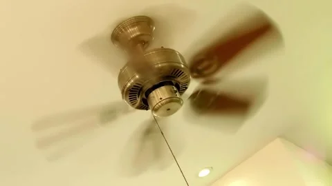 Well polished shining metallic ceiling fan of golden color rotates Stock Footage 330893644