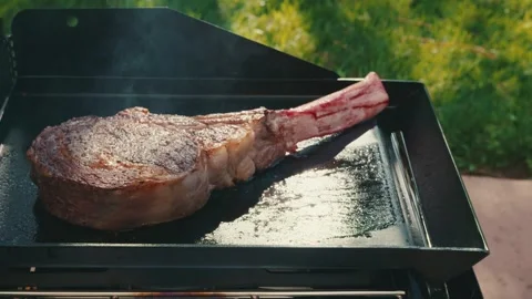 Well seared tomahawk streak grilling outside Stock Footage 276668951