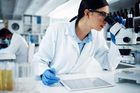 Well thats an interesting development. a young scientist using a microscope and Stockfoto's