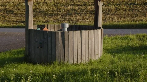 Well with wooden cladding on meadow Video stock 221153879