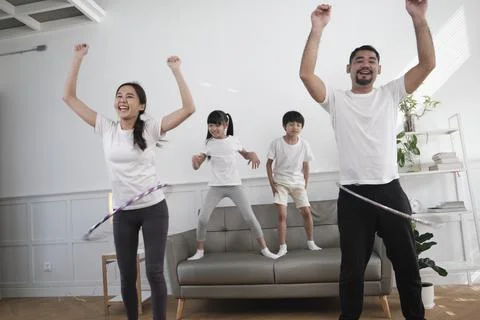 The wellness Asian Thai family is fun playing hula hoops together. Stock Photos