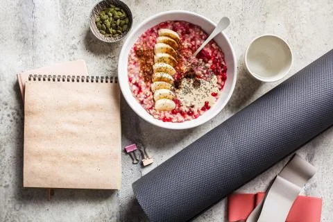 Wellness concept. Healthy food (oatmeal) and sport items, flat lay, top view. Stock Photos