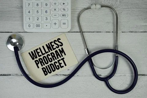 Wellness Program Budget text with Stethoscope and calculator on wooden back.. Stock Photos