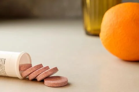 Wellness routine with effervescent tablets and fresh orange on sunny countertop Stock Photos