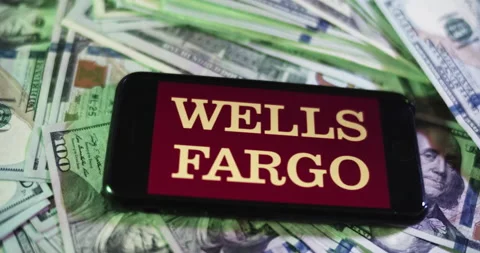 Wells Fargo Logo on iphone surrounded by $100 Bills. Bank Profits Layout. Stock Footage 169007647