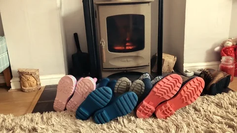 Welly boots drying by a log burner Video stock 88886595
