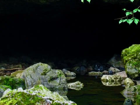 A Welsh Cave With A River Flowing Through Surrounded By Moss Covered Rocks Stock Photos
