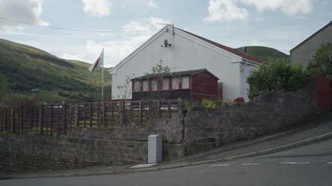 Welsh Flag in Wind In Green Valleys Village Landscape Vídeo Stock 285176886