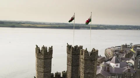 Welsh flags flying over Caernarfon Castle towers Video stock 336756439