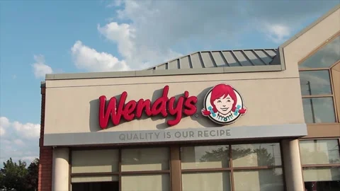 Wendys restaurant logo on building store above windows exterior outside summer Stock Footage 249760058