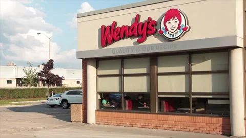 Wendys restaurant logo on building store above windows exterior outside summer Stock Footage 249760161