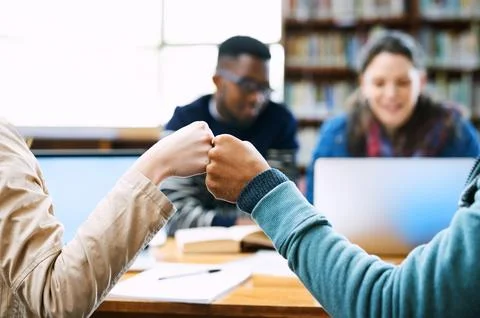 Were going to ace those tests. Rearview shot of two students fist bumping in the Stock Photos