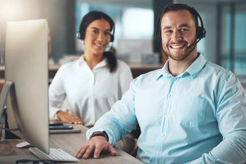 Were the team that solves problems. two young call centre agents sitting Stock Photos