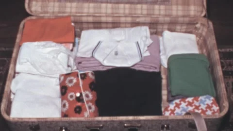 West Germany - 1973: empty luggage with holiday vacation clothes stack timelapse Stock Footage 214274191