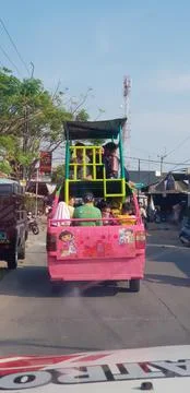 West Java in April 2019. A group of children ride in a pick-up car that has a Stock Photos