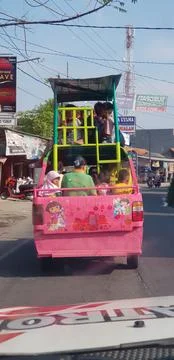 West Java in April 2019. A group of children ride in a pick-up car that has a Stock Photos