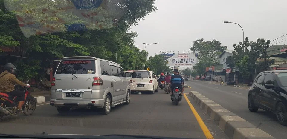West Java in April 2019. Rear view of motorbikes and cars in an arterial road Stockfoto's