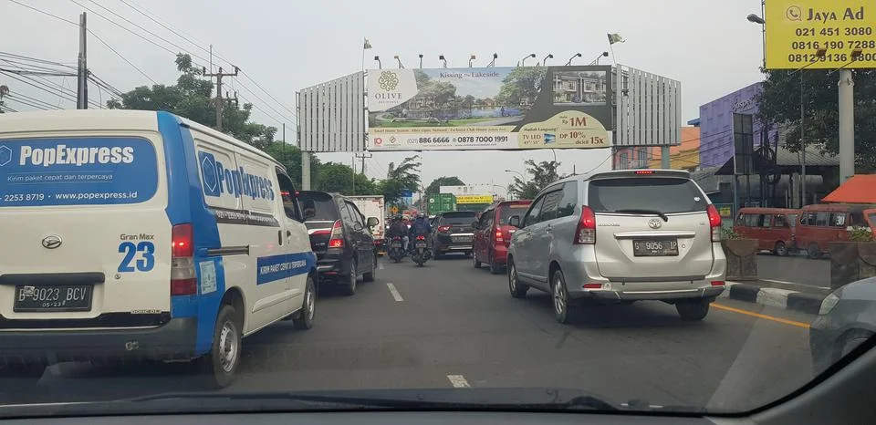 West Java in April 2019. Rear view of motorbikes and cars in an arterial road Stockfoto's