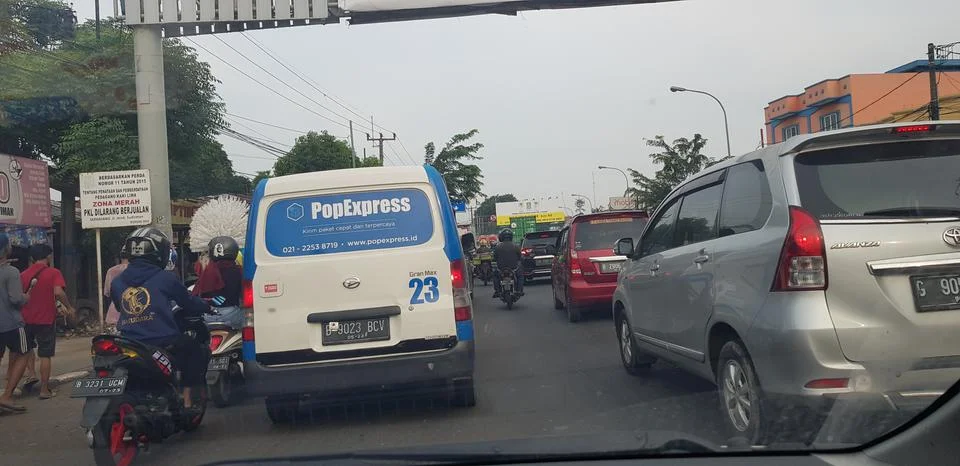West Java in April 2019. Rear view of motorbikes and cars in an arterial road Stockfoto's