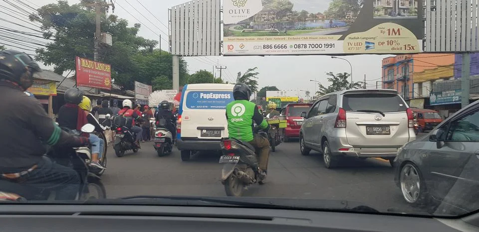 West Java in April 2019. Rear view of motorbikes and cars in an arterial road Foto stock