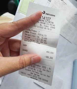 West Java, Indonesia in January 2023. A hand is holding a fuel purchase rec.. Stock-Fotos