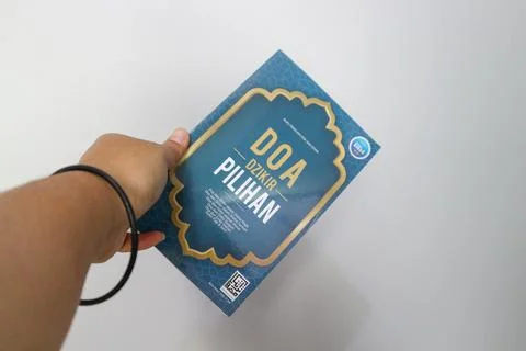 West Java, Indonesia on July 2022. A hand is holding a book of selected pra.. Stock-Fotos
