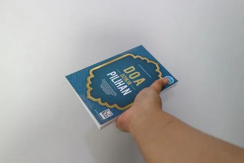 West Java, Indonesia on July 2022. A hand is holding a book of selected pra.. Stock-Fotos