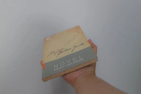 West Java, Indonesia on July 2022. A hand is holding a novel which is very .. Foto stock