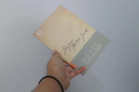 West Java, Indonesia on July 2022. A hand is holding a novel which is very .. 스톡 사진