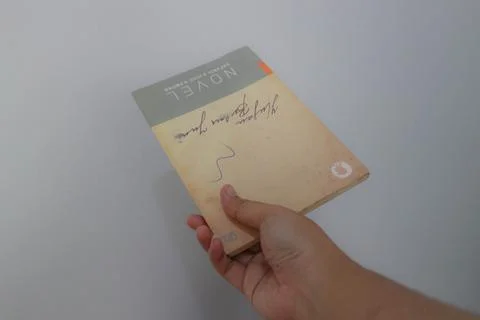 West Java, Indonesia on July 2022. A hand is holding a novel which is very .. Stock Photos