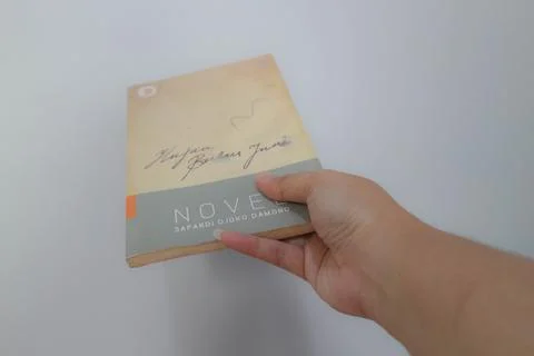 West Java, Indonesia on July 2022. A hand is holding a novel which is very .. Stock Photos