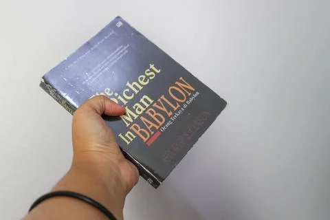 West Java, Indonesia on July 2022. A hand is holding a novel The Richest Ma.. Stock-Fotos