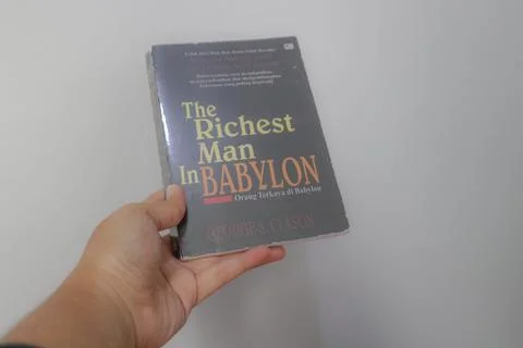 West Java, Indonesia on July 2022. A hand is holding a novel The Richest Ma.. Stock-Fotos