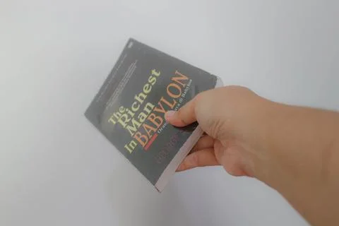 West Java, Indonesia on July 2022. A hand is holding a novel The Richest Ma.. Stock Photos