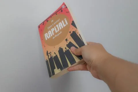 West Java, Indonesia on July 2022. A hand is holding a novel called Rapijal.. Foto stock