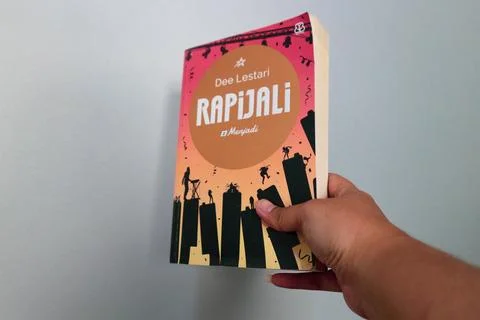 West Java, Indonesia on July 2022. A hand is holding a novel called Rapijal.. Stock Photos