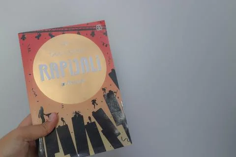 West Java, Indonesia on July 2022. A hand is holding a novel called Rapijal.. Foto stock