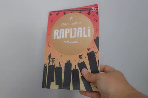 West Java, Indonesia on July 2022. A hand is holding a novel called Rapijal.. Stock Photos