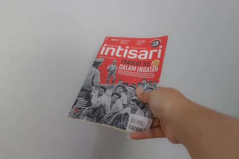 West Java, Indonesia on July 2022. A hand is holding an Indonesian magazine.. Stock Photos