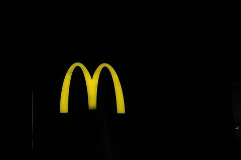 West Java, Indonesia on July 2022. Glowing McDonalds restaurant sign agains.. 库存照片