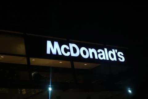 West Java, Indonesia on July 2022. Glowing McDonalds restaurant sign agains.. 库存照片