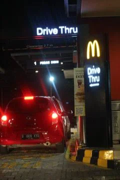 West Java, Indonesia on July 2022. Glowing McDonalds restaurant sign agains.. 库存照片