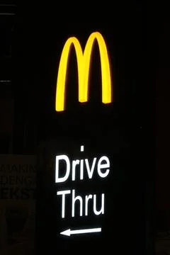 West Java, Indonesia on July 2022. Glowing McDonalds restaurant sign agains.. 库存照片