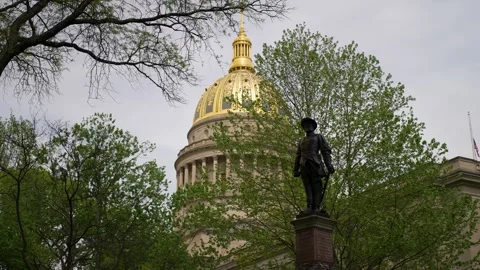 West Virginia State Capitol Surrounded by Trees and a Historic Statue Stock Footage 308241095
