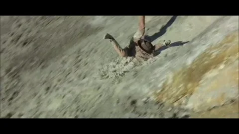 Western - Men slide down a hill through mud Stock Footage 284656032