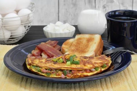 Western Omelet breakfast with toast and bacon.  Selective focus on omelet. Stock Photos