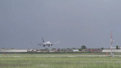 A WestJet Boeing 737 passes through light and dark as it lands Stock Footage 91546751