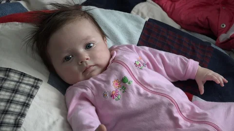 WESTMINSTER COLORADO-2015: Baby On A Patchwork Quilt Staring At The Camera Stock Footage 129349226